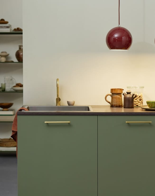 Tirador dorado con muebles de color verde pálido